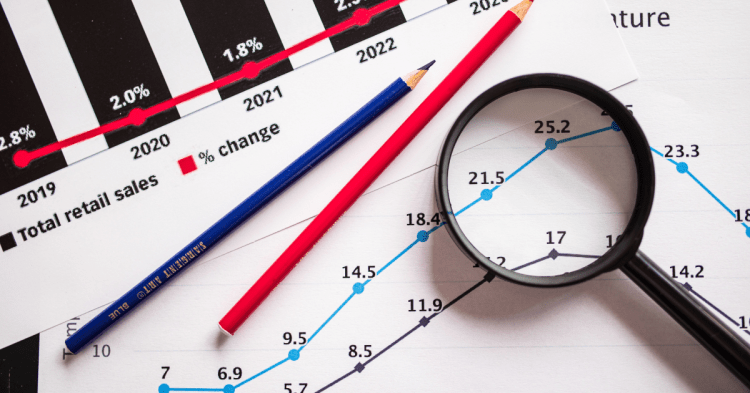 Magnifying glass and pencils on top of different graphs.